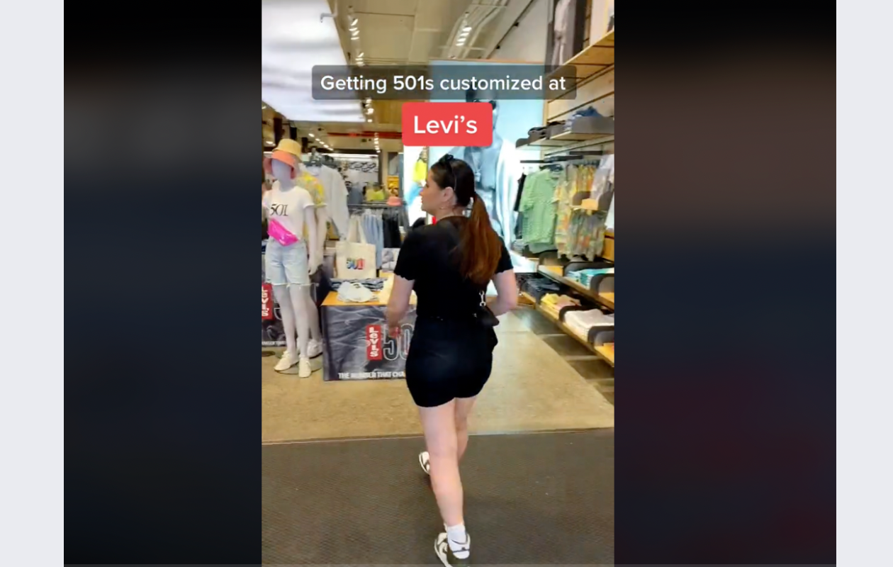 screenshot from levis tiktok with a girl wearing black walking into a levis store